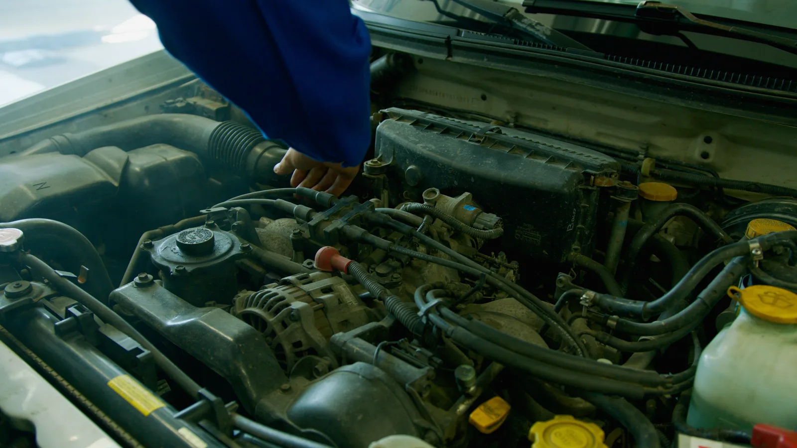 Mechanic checking a steaming van engine during a repair
