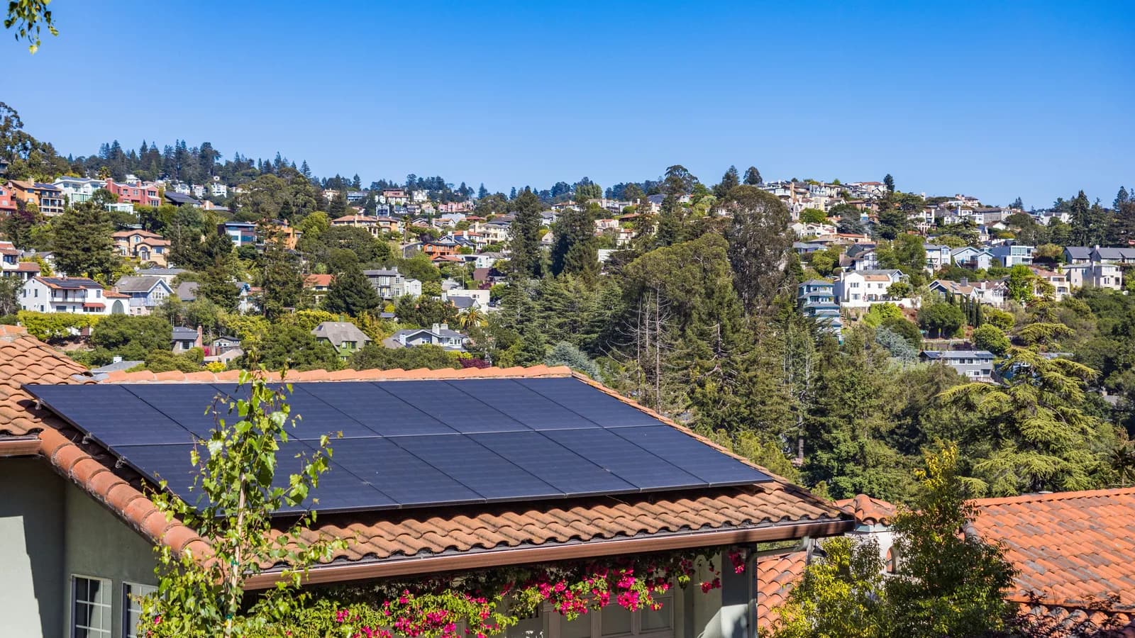Close view of solar panels installed across a tiled house roof