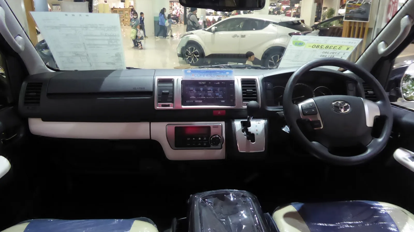 Interior of a Japanese-market Toyota HiAce showing the dashboard and audio screen from the passenger side