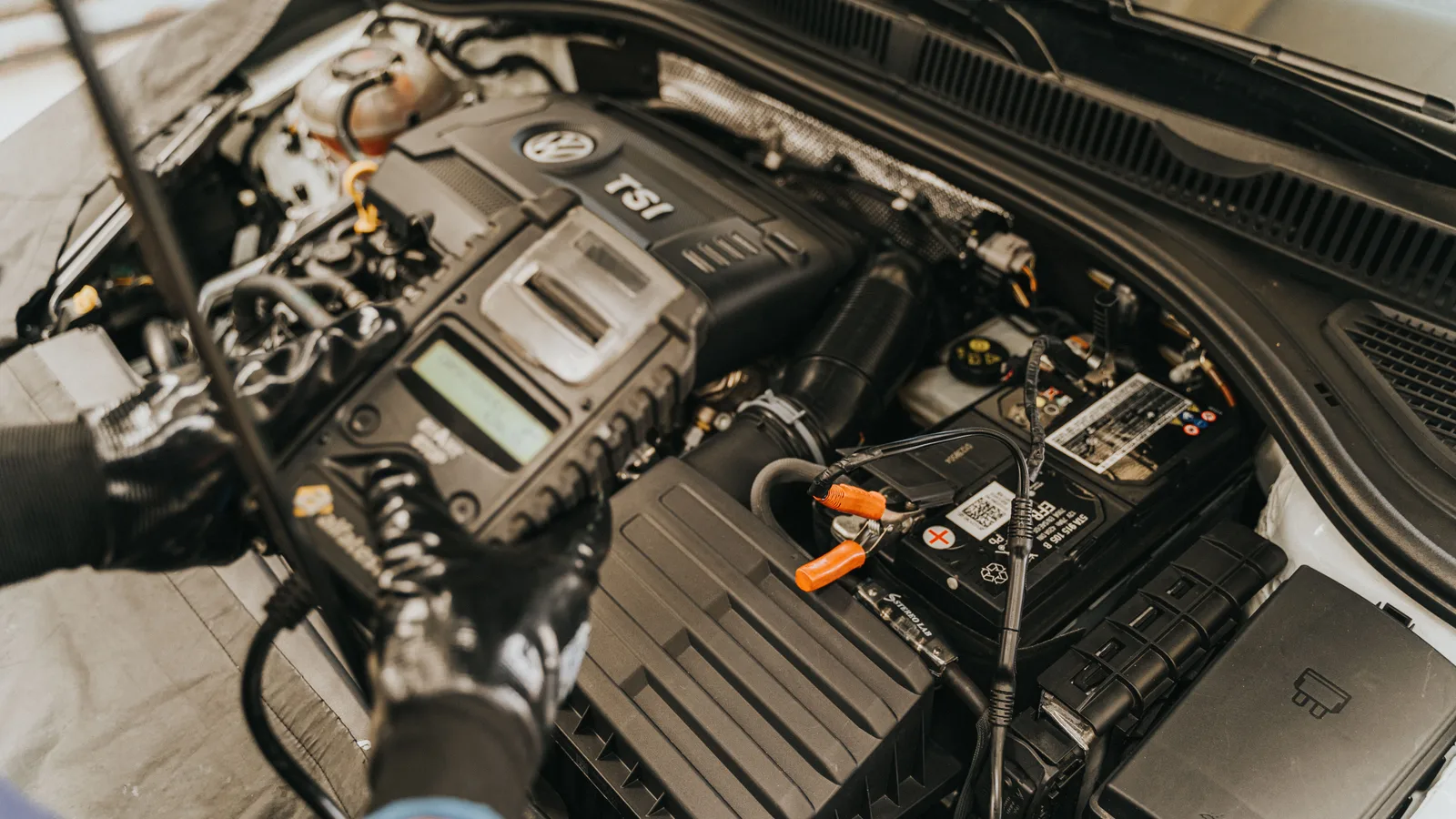 A mechanic using a scan tool plugged into a car's diagnostic port