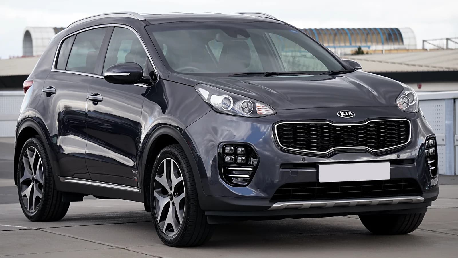 A dark grey Kia Sportage parked in an outdoor car park