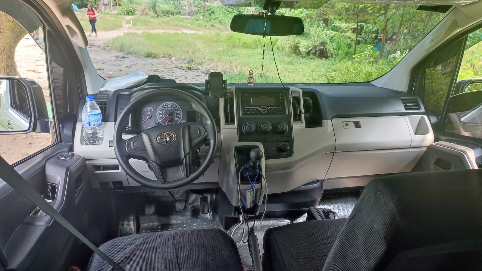 View across the dashboard and instrument cluster of a Toyota HiAce from the driver's side