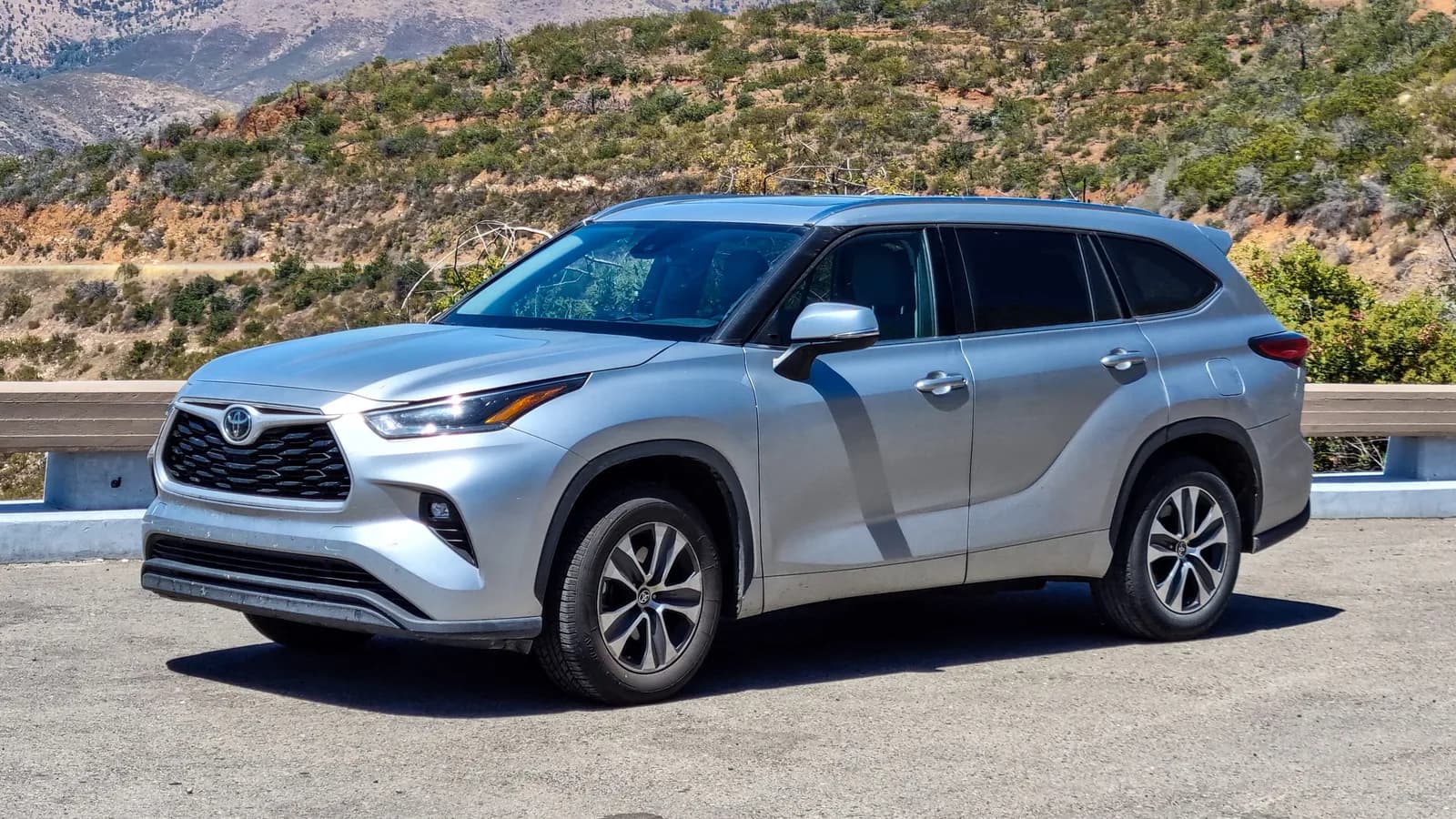A silver Toyota Highlander, the US-market version of the Kluger, parked on a mountain roadside
