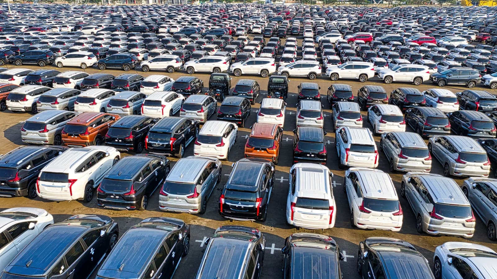 Rows of new SUVs filling a large outdoor vehicle storage yard