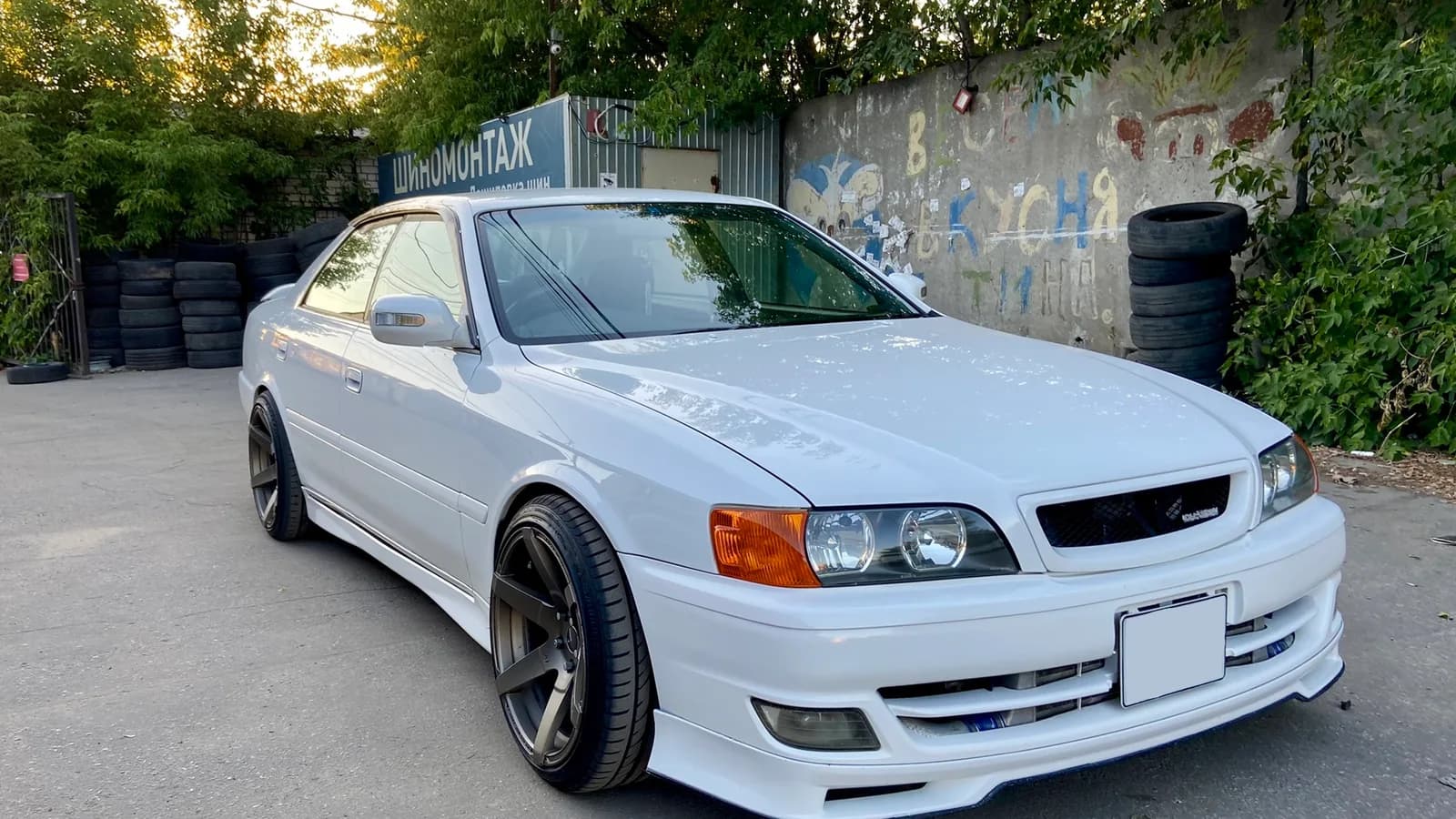 White Toyota Chaser displayed for sale in a tyre yard