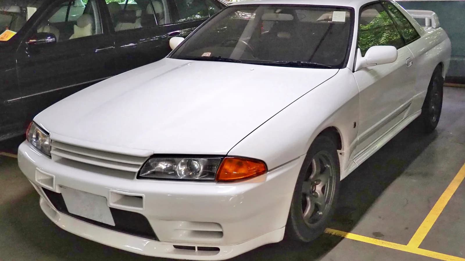 White Nissan Skyline GT-R parked under indoor lighting