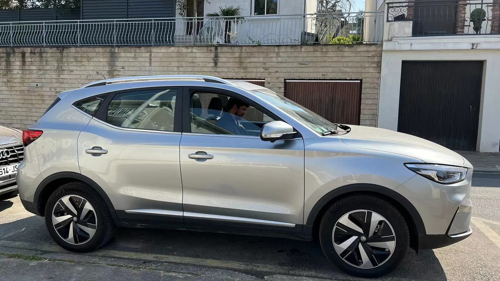 A silver MG SUV parked at the kerb, photographed side on