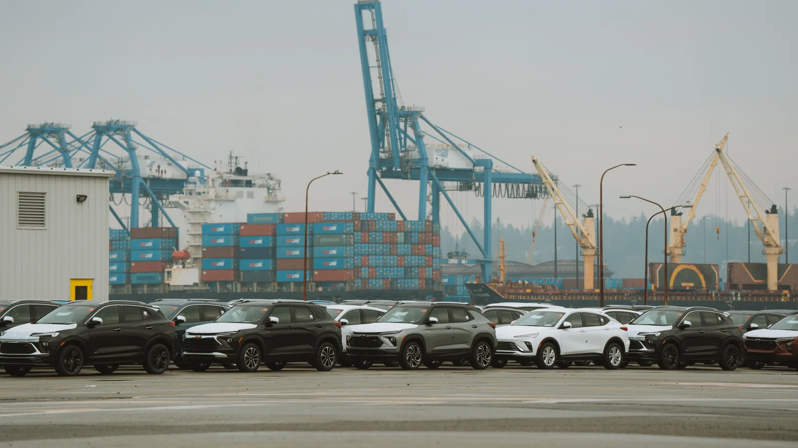 Imported vehicles parked in long lines at a container port