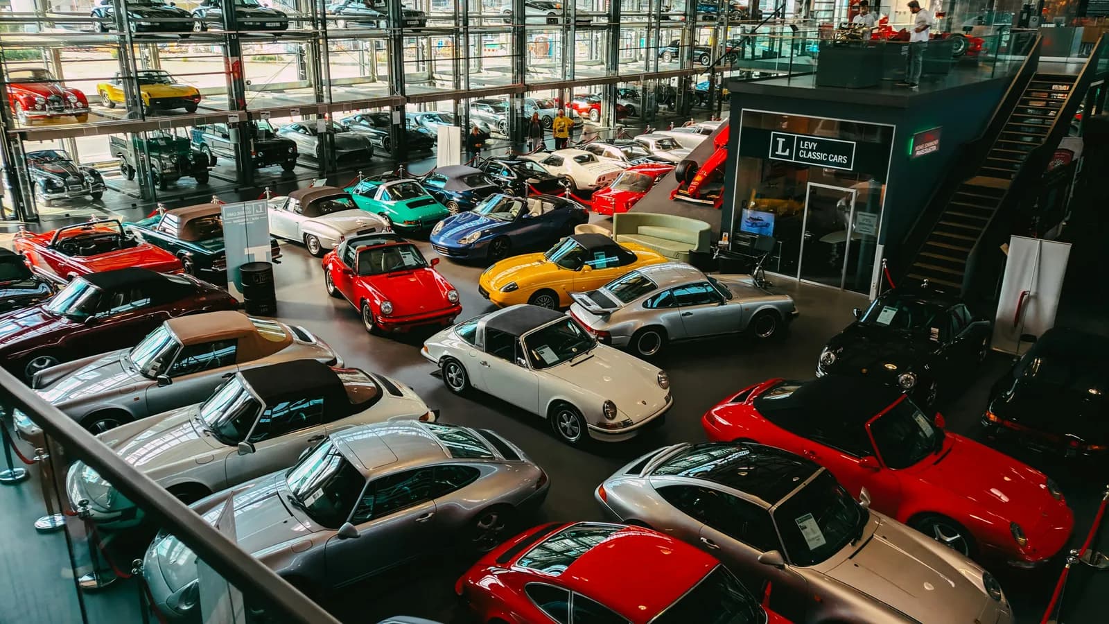 Buyers walking among rows of cars in a multi-level showroom