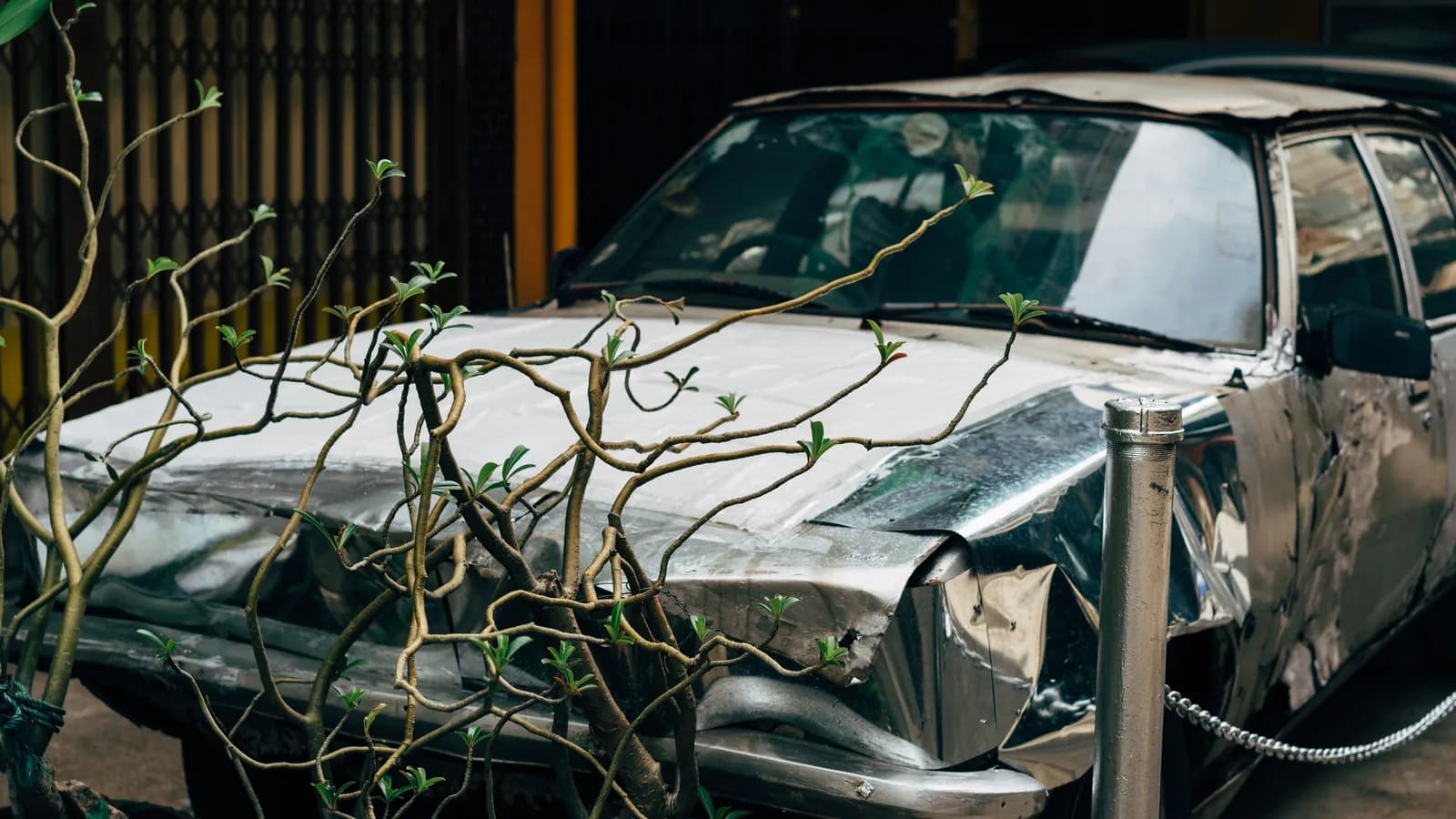 Silver sedan with severe crash damage across its front end