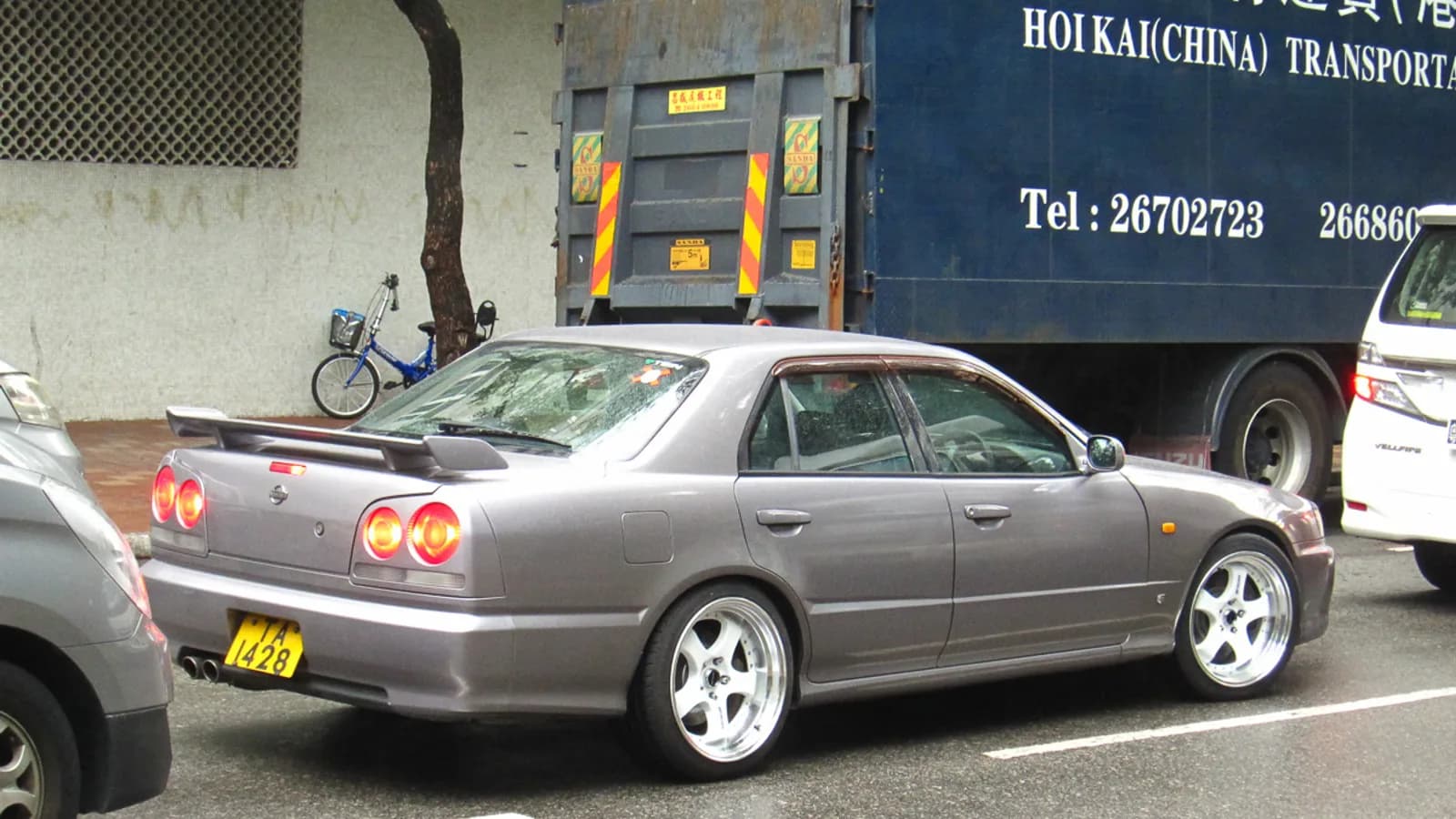 Silver Nissan Skyline sedan parked on a city street