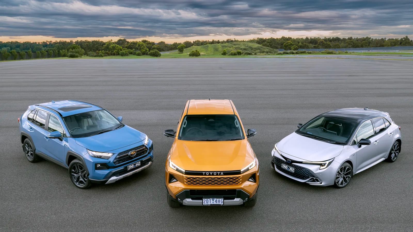 Three Toyota models parked side by side outdoors, viewed from the front three-quarter angle
