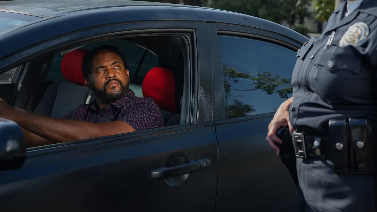 Motorist seated in a car speaking with a police officer through the open window