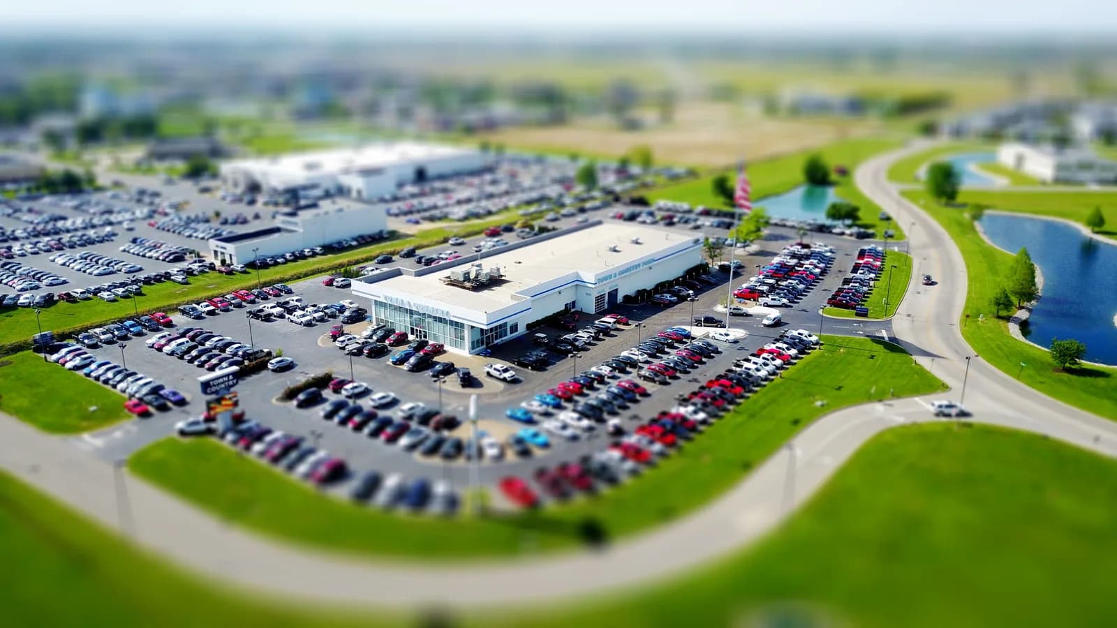 Aerial view of a dealership lot packed with rows of parked cars