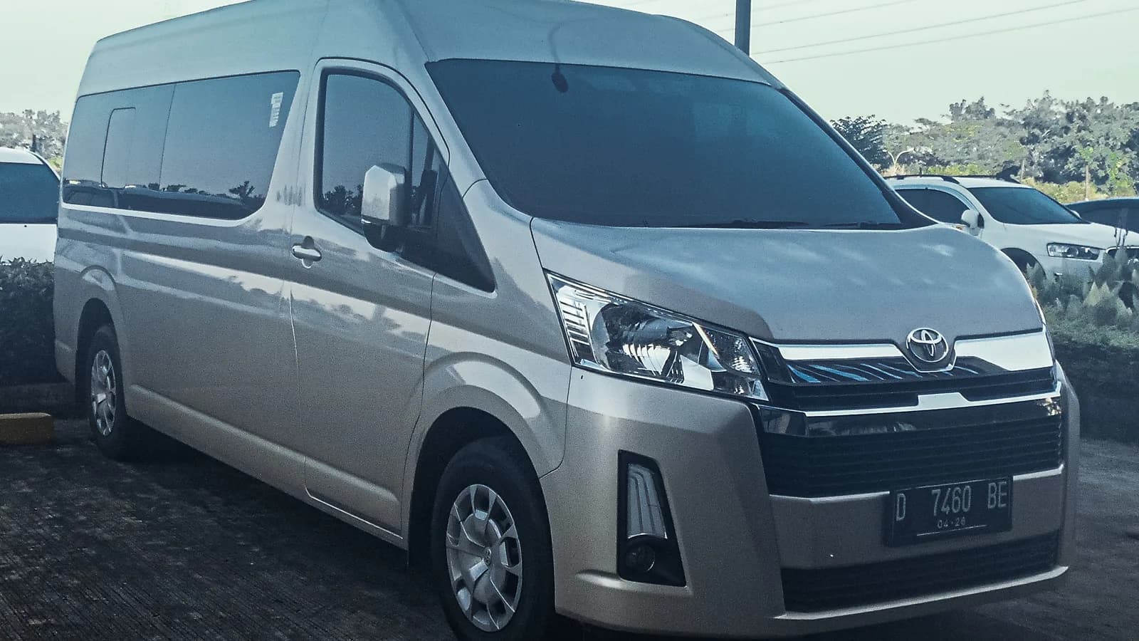 A silver Toyota HiAce van parked in a car park, seen from the front three-quarter angle