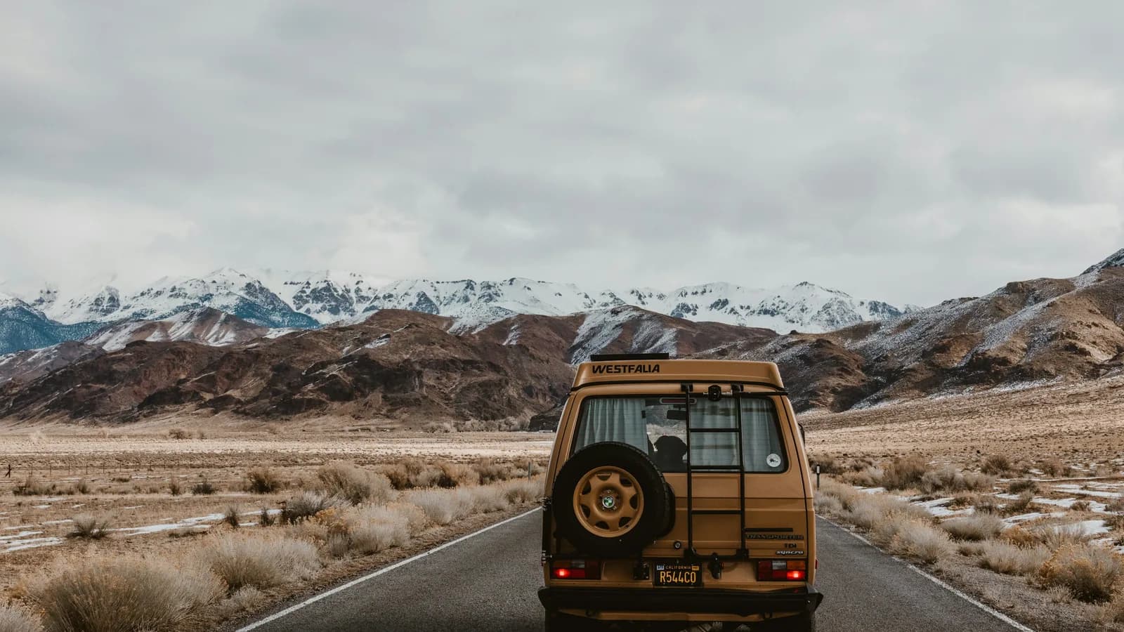 Loaded camper van travelling along a remote mountain road